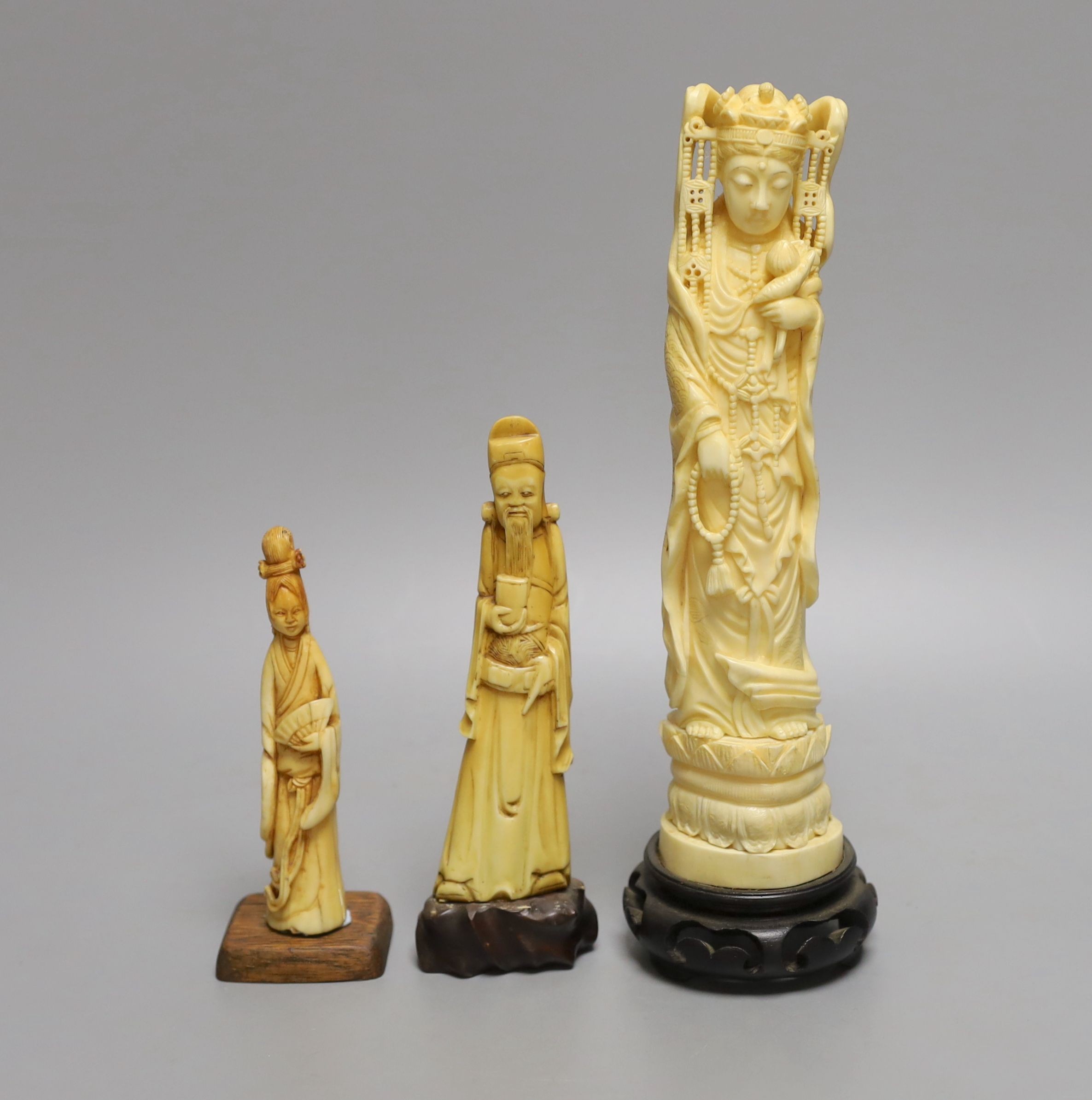 A Japanese walrus ivory figure of Kwannon and two Chinese hippo tusk? figures, early 20th century (3), wood stands, tallest 24cm (including base)